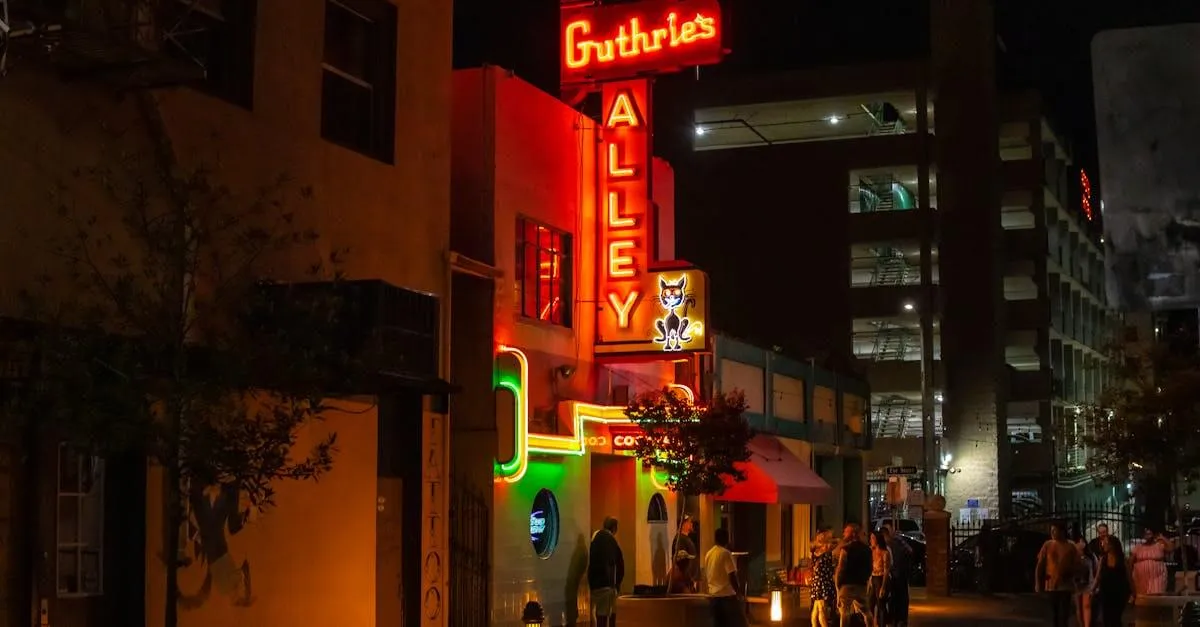 Vibrant night street scene with neon signs at Bakerville's Guthrie's Alley Cat.