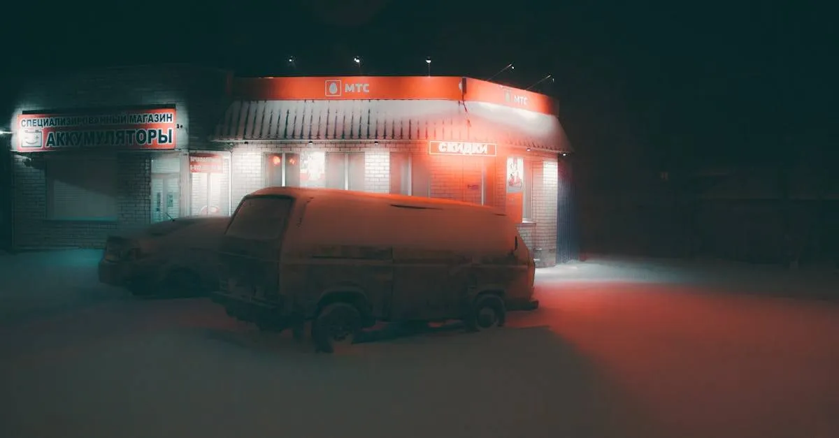 A snow-covered van parked in front of a brightly lit storefront at night in Saint Petersburg.