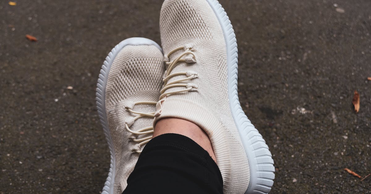 Fashionable cream sneakers on pavement, showcasing casual urban style.