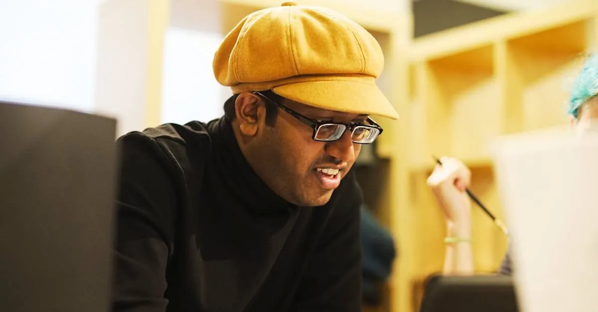 An engaged individual wearing a yellow cap and glasses is focused on work indoors.