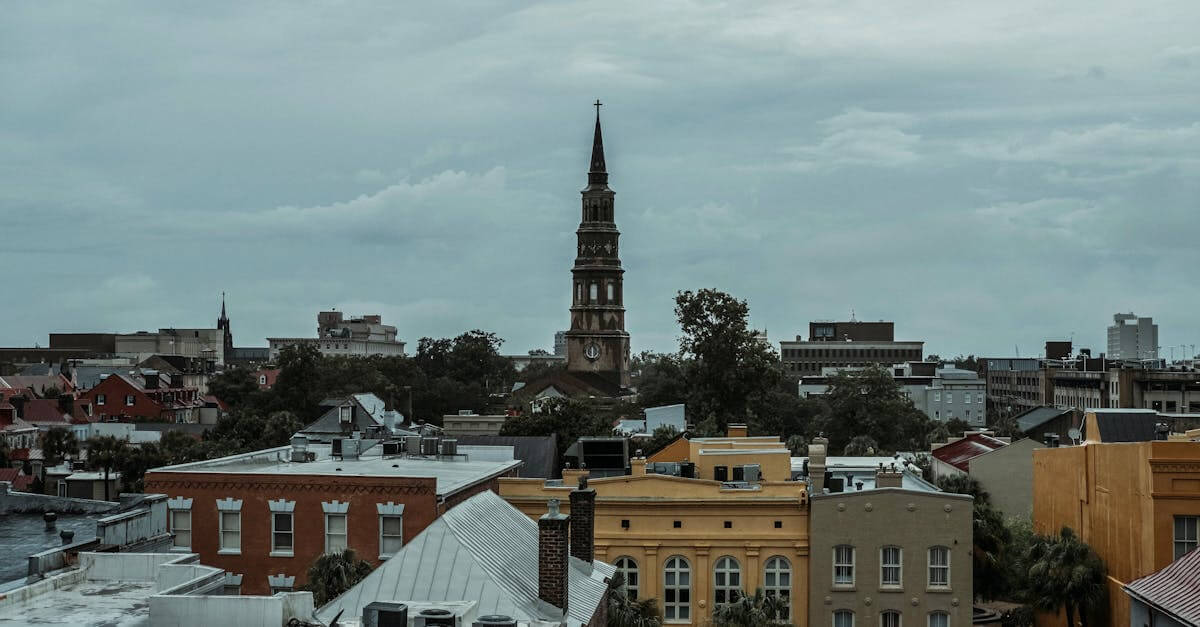 A picturesque view of Charleston, SC, featuring a historic church tower amidst vibrant buildings.