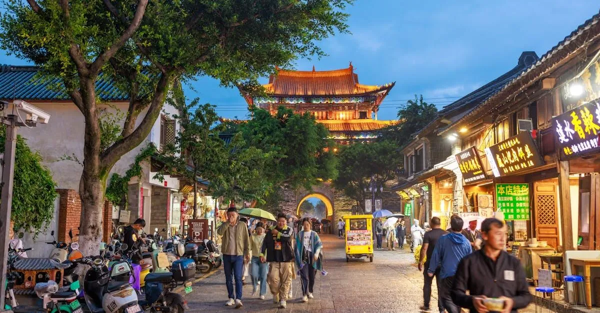 Vibrant street scene in Dali, China featuring people, shops, and historic architecture at dusk.