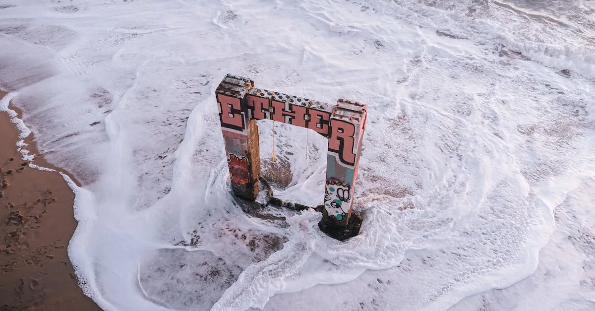 An aerial shot of graffiti-covered ruins amidst the sea foam at Davenport Beach, CA.