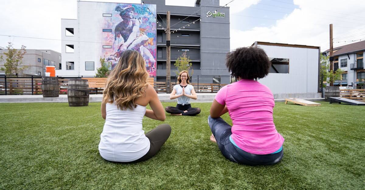 Three women practicing yoga outdoors in Denver, embracing mindfulness and healthy living.