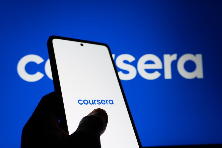 A smartphone screen showing the Coursera logo with a background featuring the same logo.