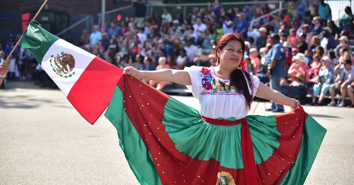 A woman in traditional Mexican attire dances with a Mexican flag during a street parade in Fayetteville.