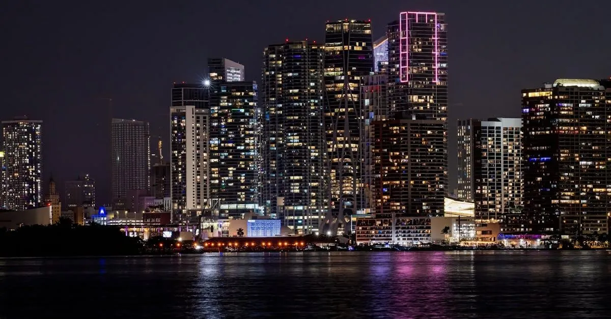 A stunning view of Miami's illuminated skyline reflecting on water at night.