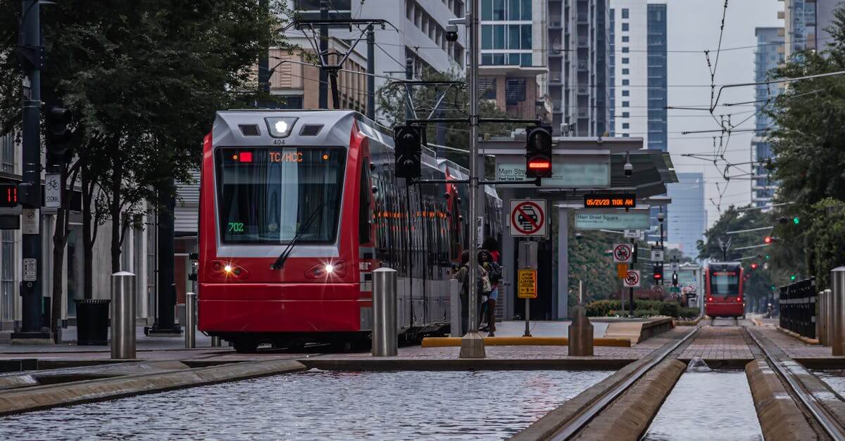 A modern red train travels along Main Street in downtown Houston, Texas.