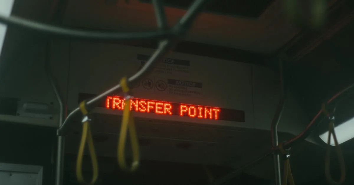 Moody interior bus shot with 'Transfer Point' sign, featuring hanging handles.