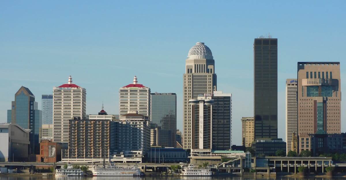 Stunning view of Louisville's skyline with modern skyscrapers reflecting on river.