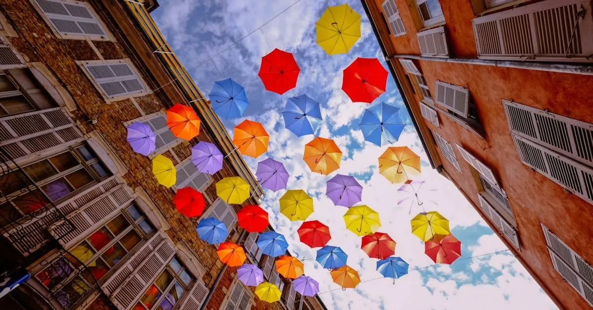 Colorful umbrellas suspended between historic buildings in Mâcon, France.