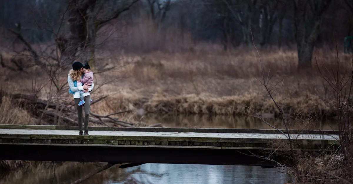 A mother holding her child on a bridge in a serene forest landscape.