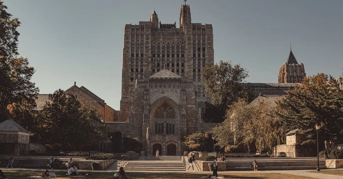 View of Yale University's neoclassical architecture with lawns and students relaxing outdoors.