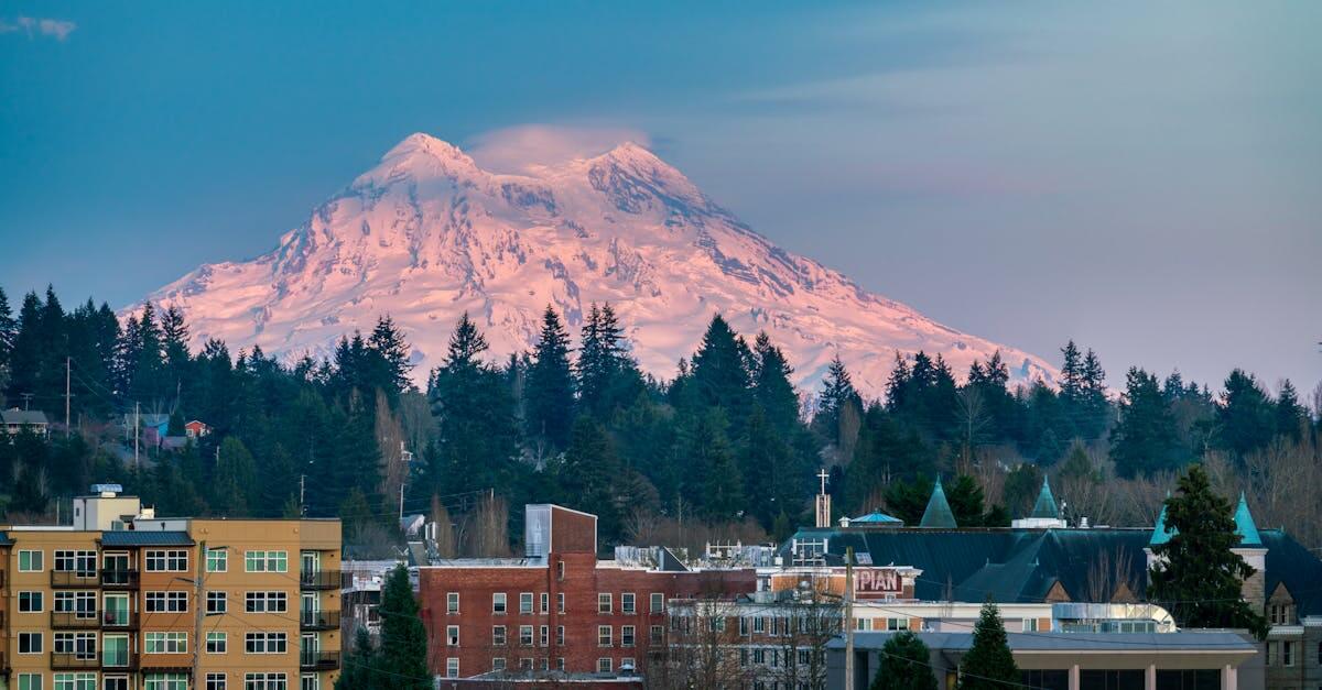 Olympia city skyline with snowcapped Mount Rainier in the background at sunset.