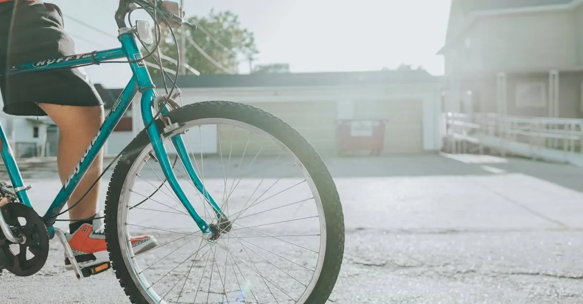 Teen biking along an urban street with sunlight, focusing on teal bicycle and vibrant atmosphere.