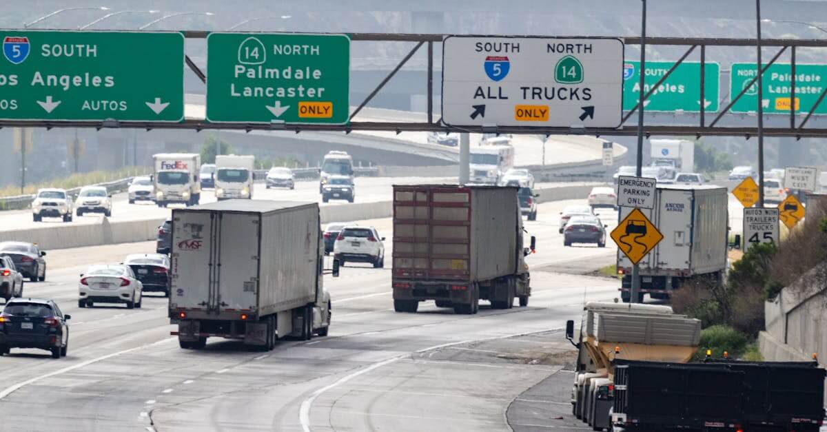 Traffic with trucks and cars on a highway in California heading to Los Angeles.