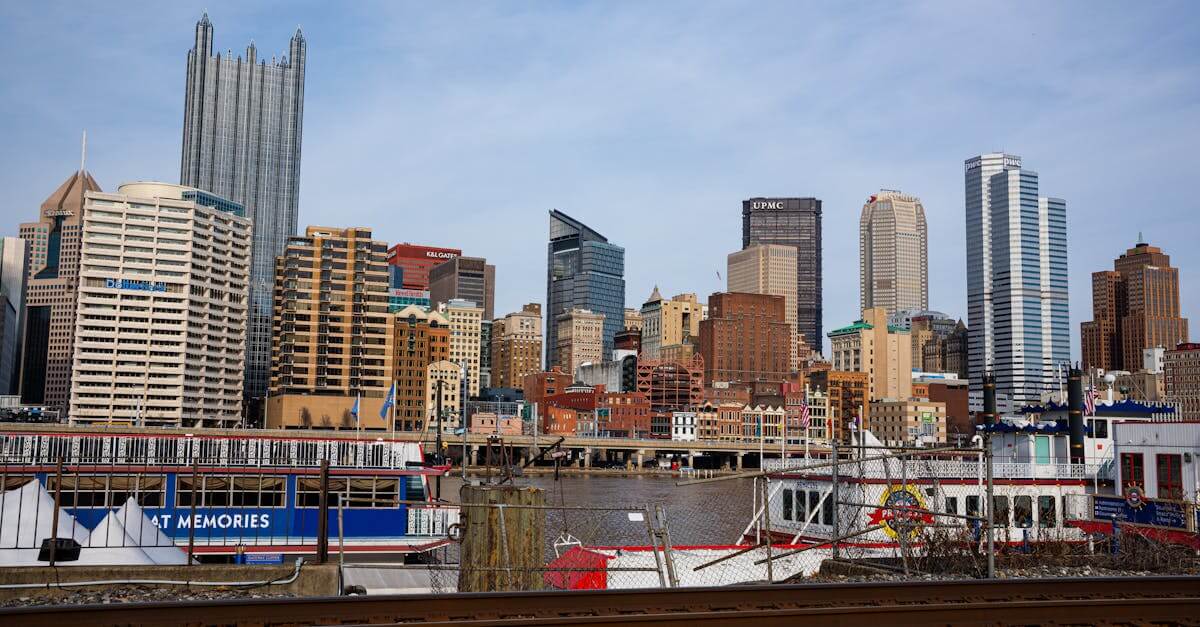 View of Pittsburgh skyline featuring prominent skyscrapers and a riverboat along the waterfront.