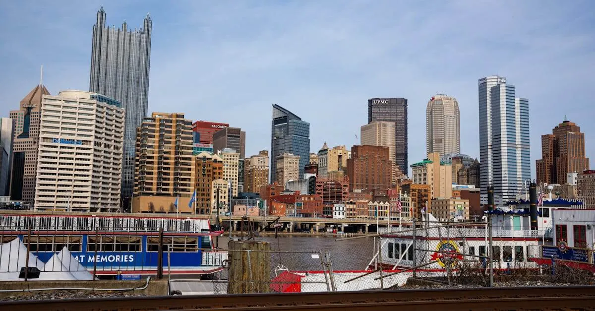 View of Pittsburgh skyline featuring prominent skyscrapers and a riverboat along the waterfront.