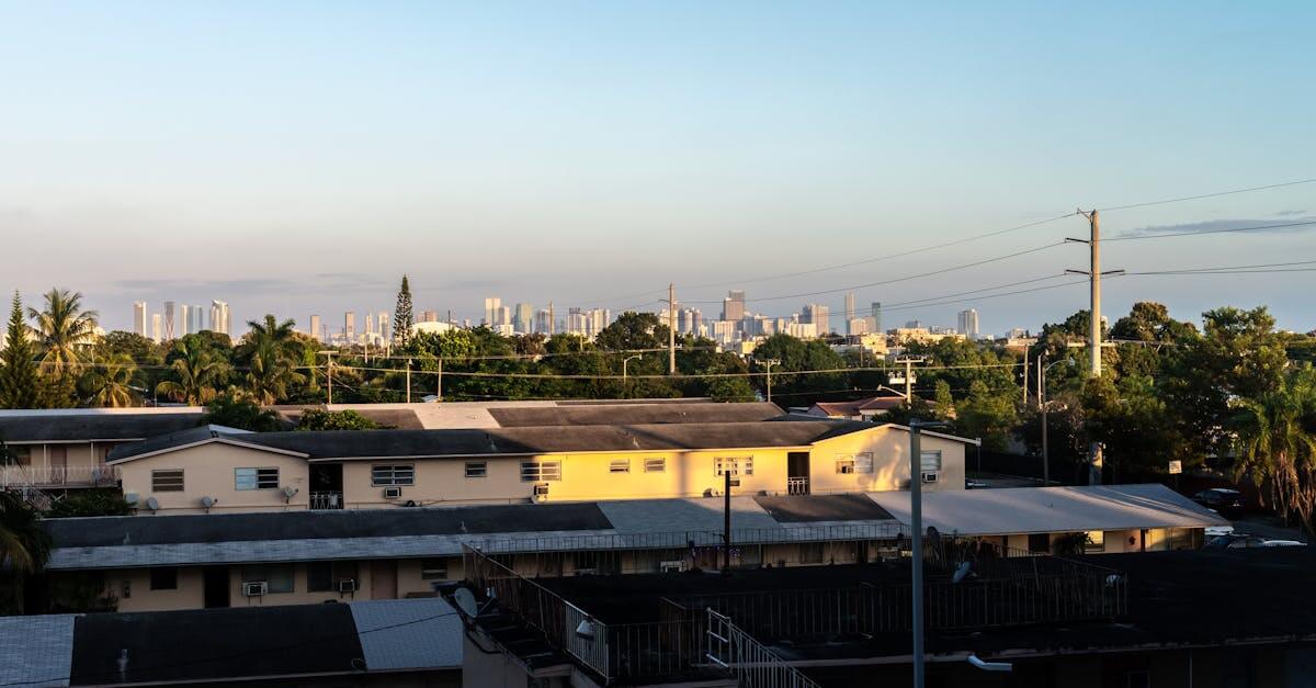 View of Miami skyline from Coral Gables at sunset with residential buildings in foreground.