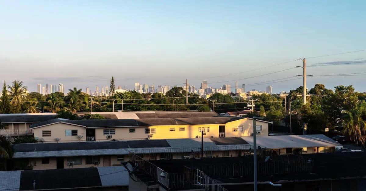 View of Miami skyline from Coral Gables at sunset with residential buildings in foreground.