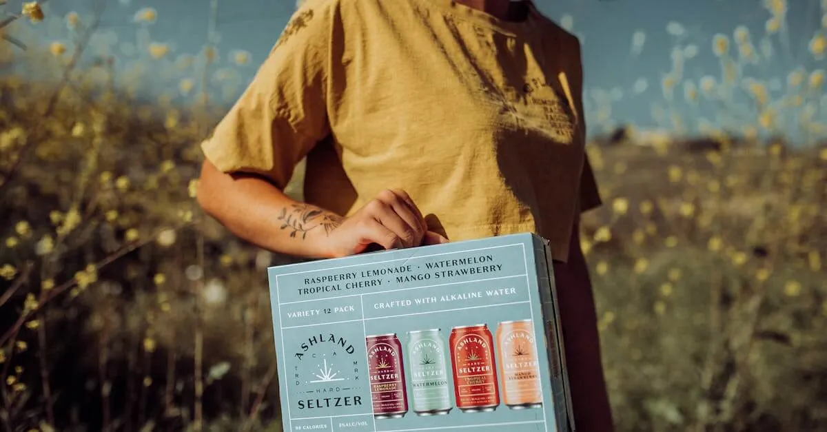 Person holding Ashland Seltzer variety pack outdoors with wildflowers.