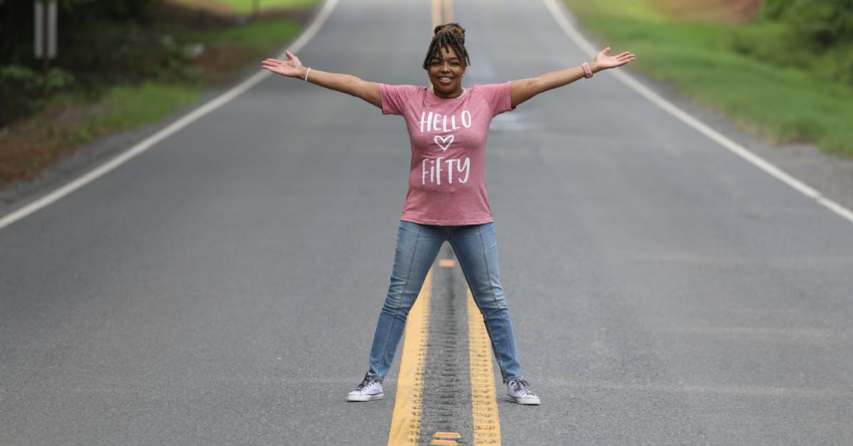 A cheerful woman celebrating her 50th birthday on a rural road in Shreveport, Louisiana.