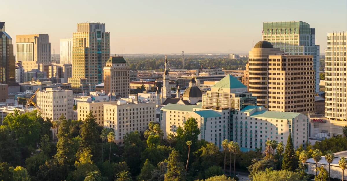 A stunning aerial view of downtown Sacramento skyline with lush greenery under the golden sunset light.