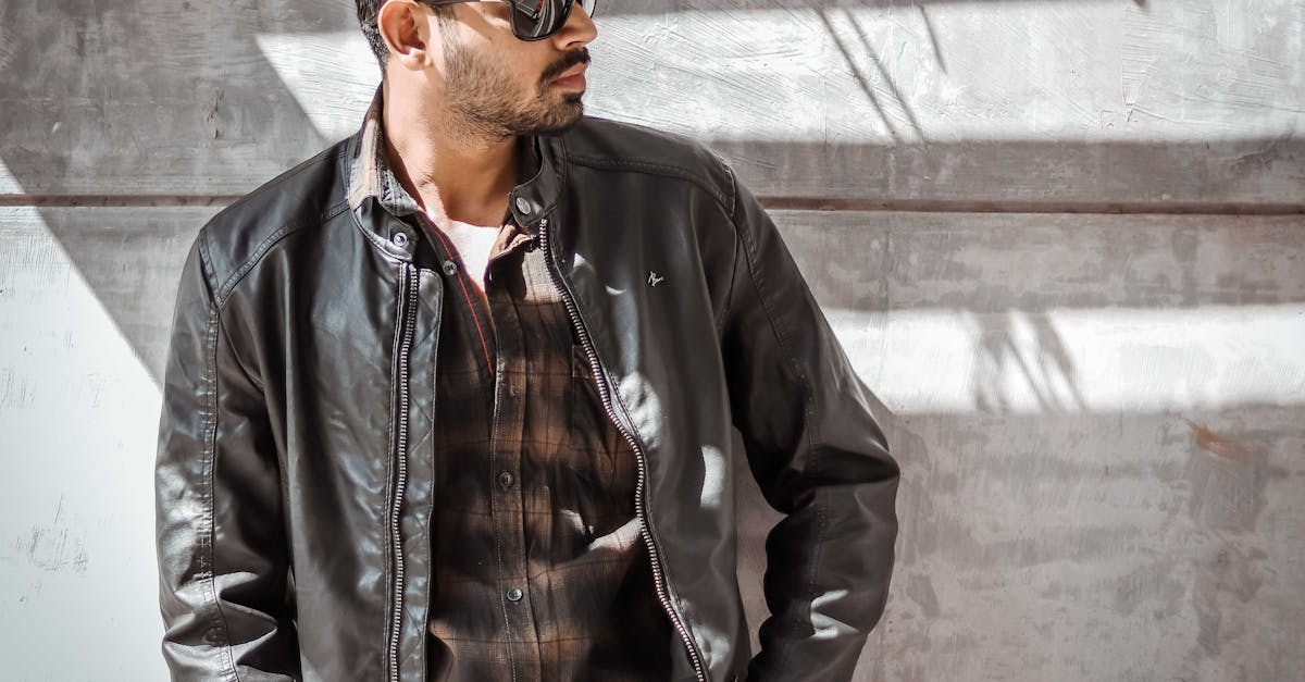 Fashionable man in leather jacket and sunglasses posing outdoors in Springfield, IL.