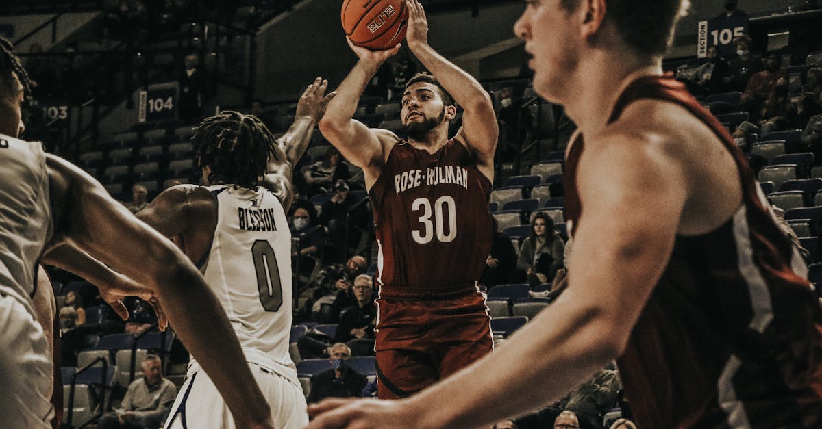 Basketball players in an intense college game action, showcasing skill on court.