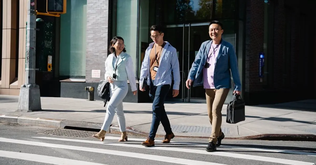 Three business professionals walking across an urban street, smiling and engaged.