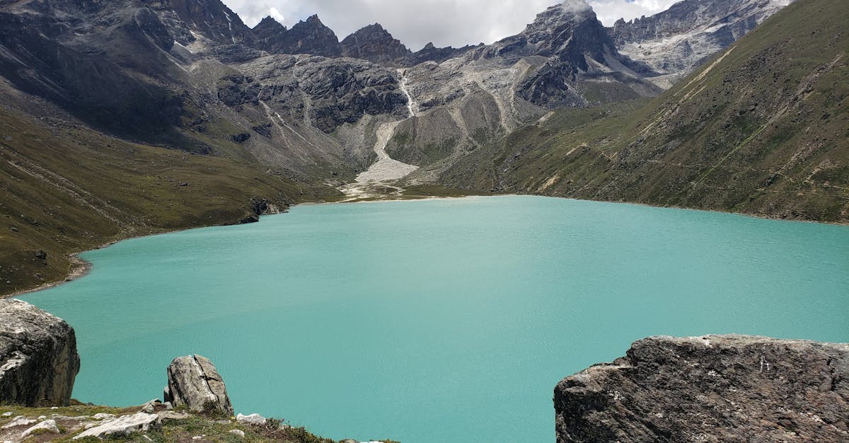 Serene view of Gokyo Lake with surrounding majestic mountains in Sagarmatha National Park, Nepal.