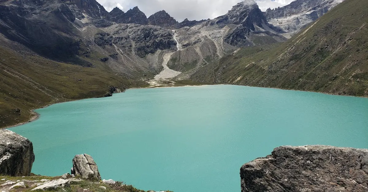 Serene view of Gokyo Lake with surrounding majestic mountains in Sagarmatha National Park, Nepal.