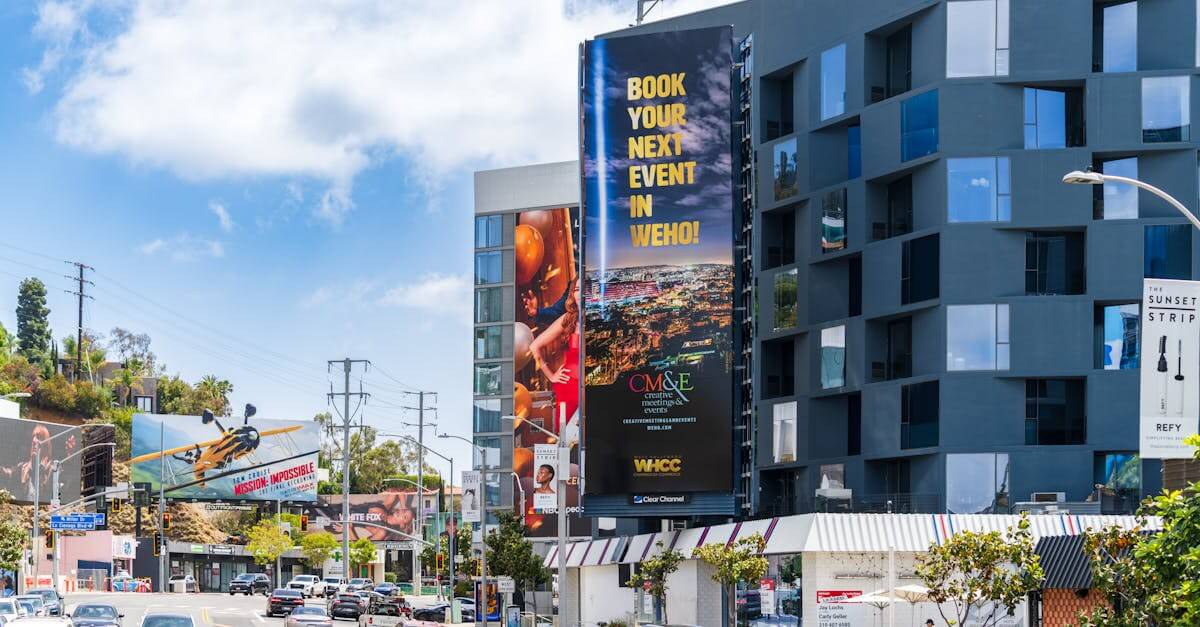 Colorful view of Sunset Boulevard with billboards and vehicles under a clear sky.