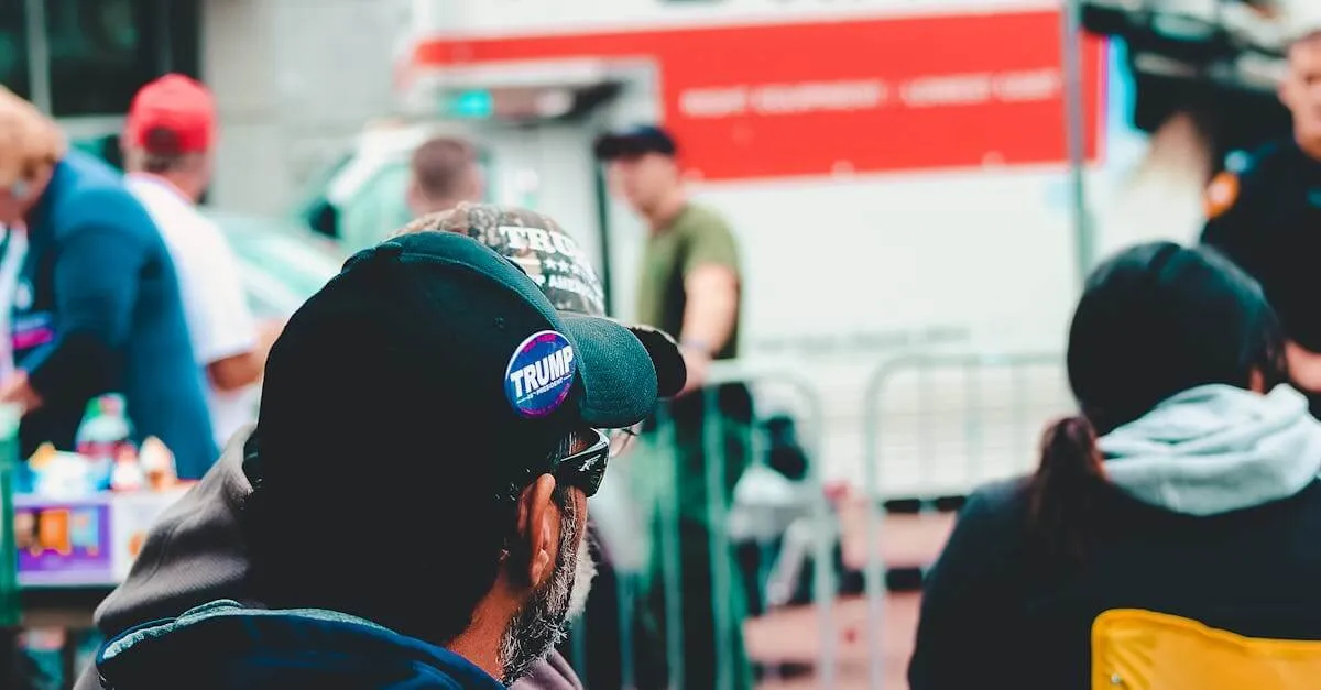 Participants at a political rally in Wheeling, WV wearing campaign merchandise with a U-Haul in the background.
